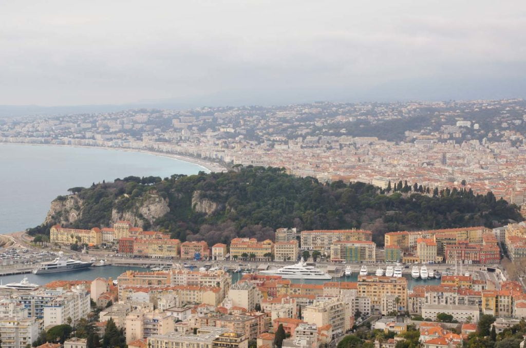 Der grüne Schlossberg Nizza vom Mont Boron aus. Ringsherum sieht man die dichte Bebauung der Innenstadt