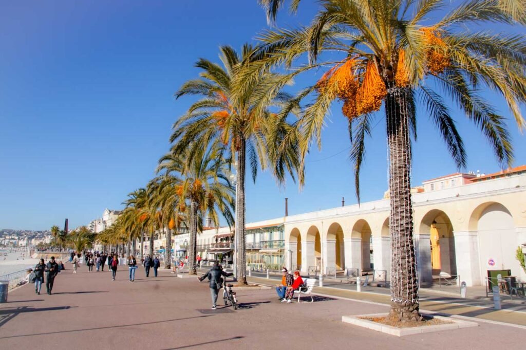 Nizza Promenade mit Palmen, Besuchern und Ponchettes