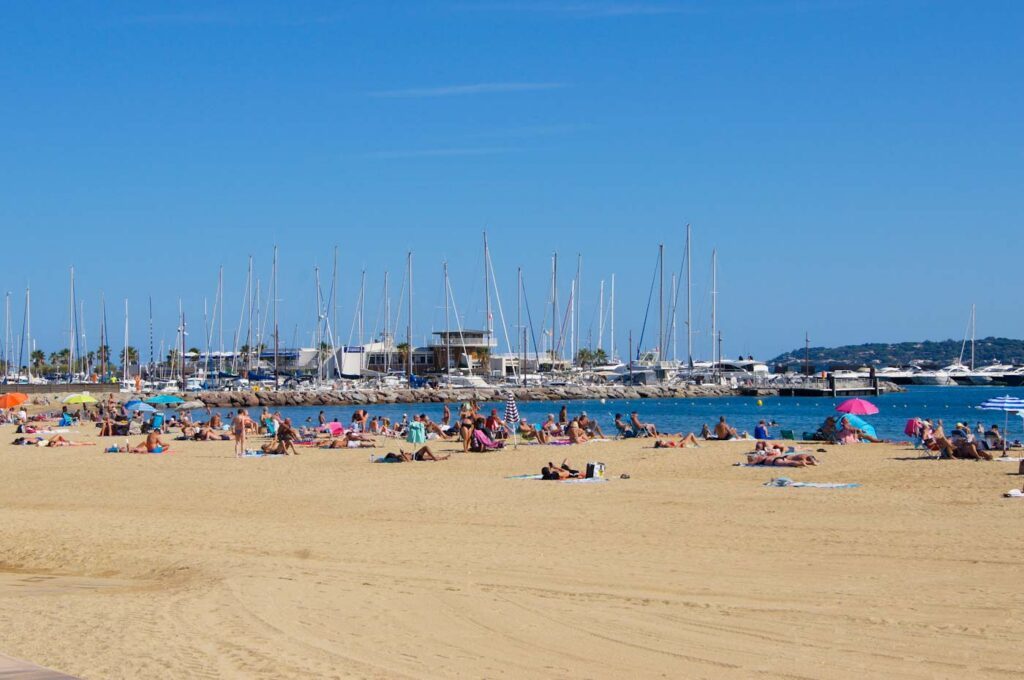 Strand im Zentrum von Sainte-Maxime mit Hafen im Hintergrund