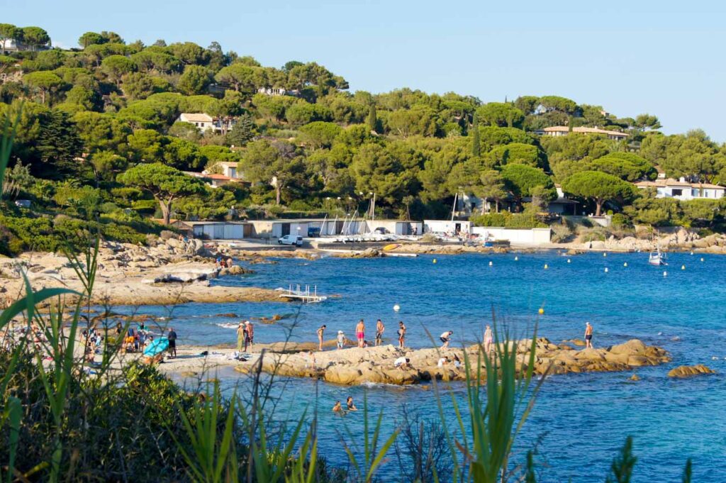 Felsiger Strand, türkisblaues Meer und üppige Vegetation