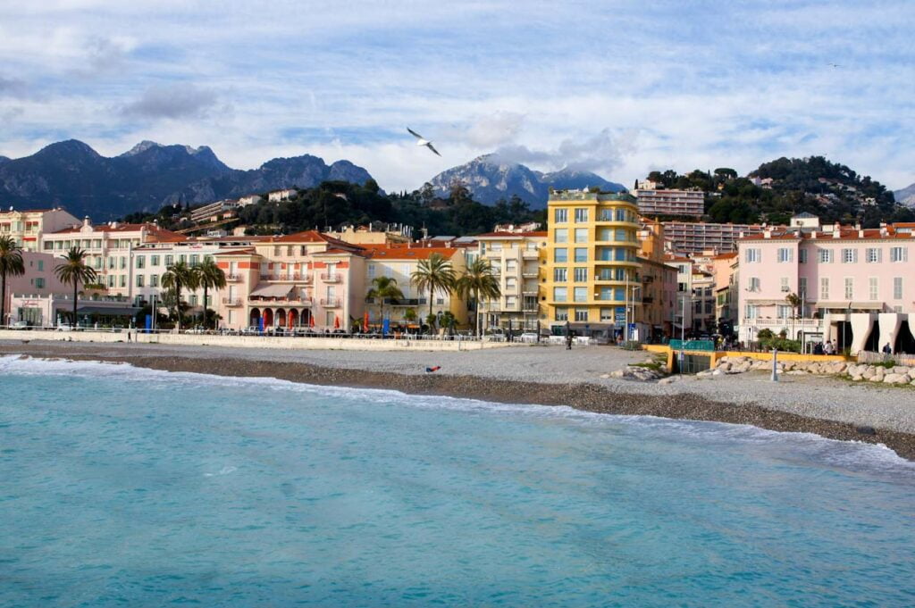 Türkisblaues Meer, Möve, Strandpromenade und Häuserfassaden