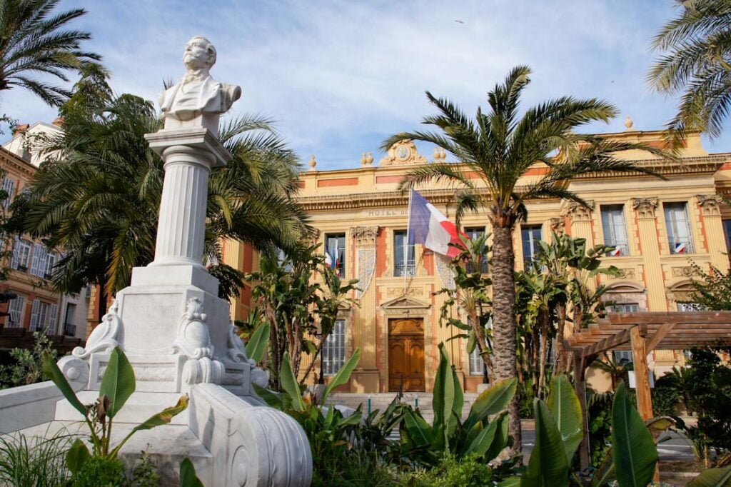 Statue und Palmengarten vor Rathaus von Menton, Frankreich