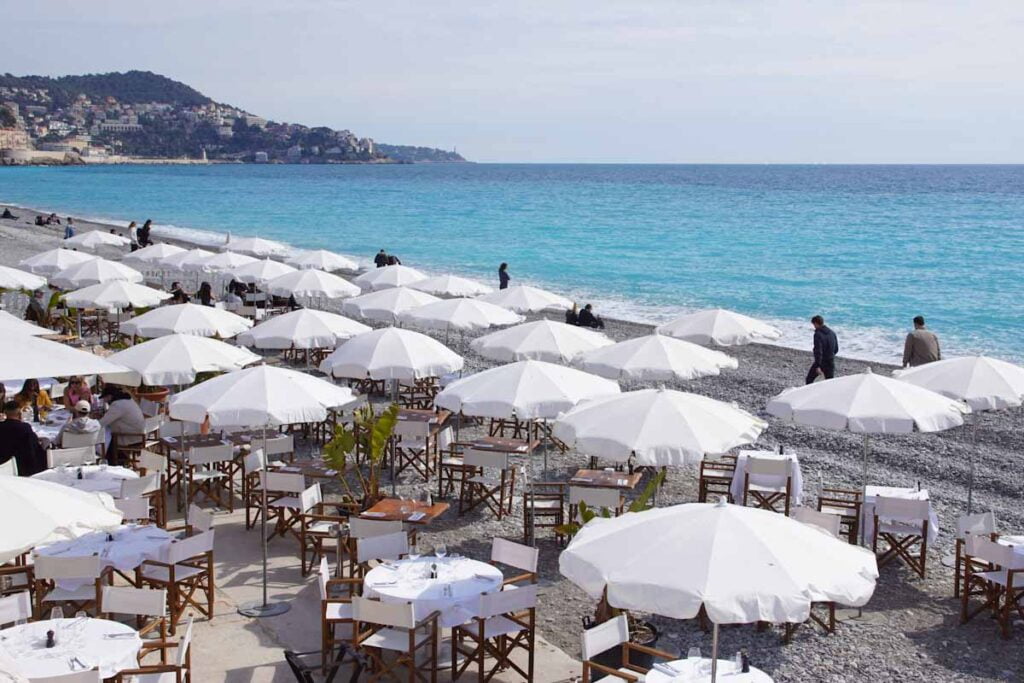 Nizza Beach Club mit weißen Sonnenschirmen