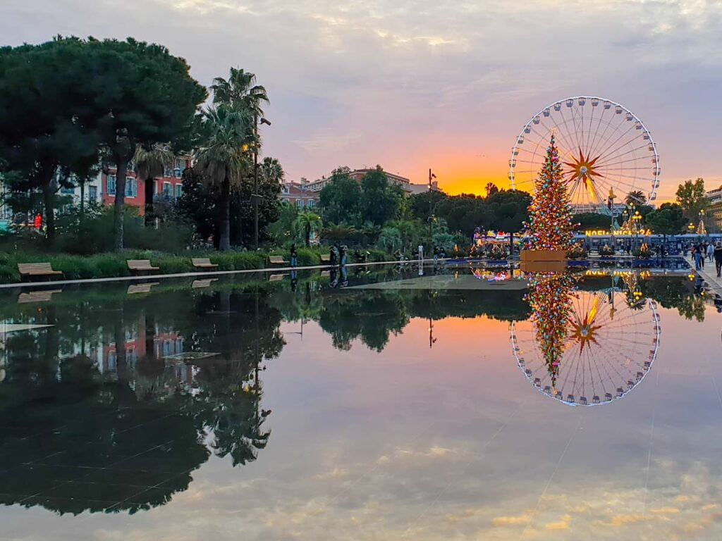 Wasserspiegel in Nizza mit Riesenrad und Weihnachtsbaum